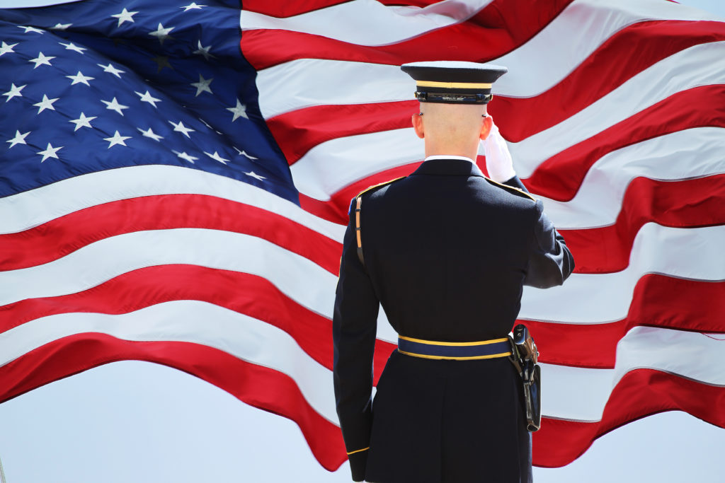 A professional technician from 24/7 Super Locksmith saluting the United States flag, representing our commitment as a patriotic Local Locksmith in Boca Raton, FL. We are proud to provide reliable Locksmith Services in Lake Worth Beach FL and emergency support across the community.